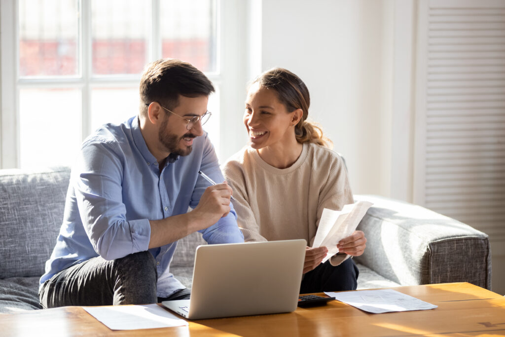 Couple smiling doing their taxes