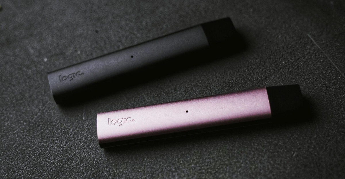 Two sleek vape devices in pink and black on a textured dark background.