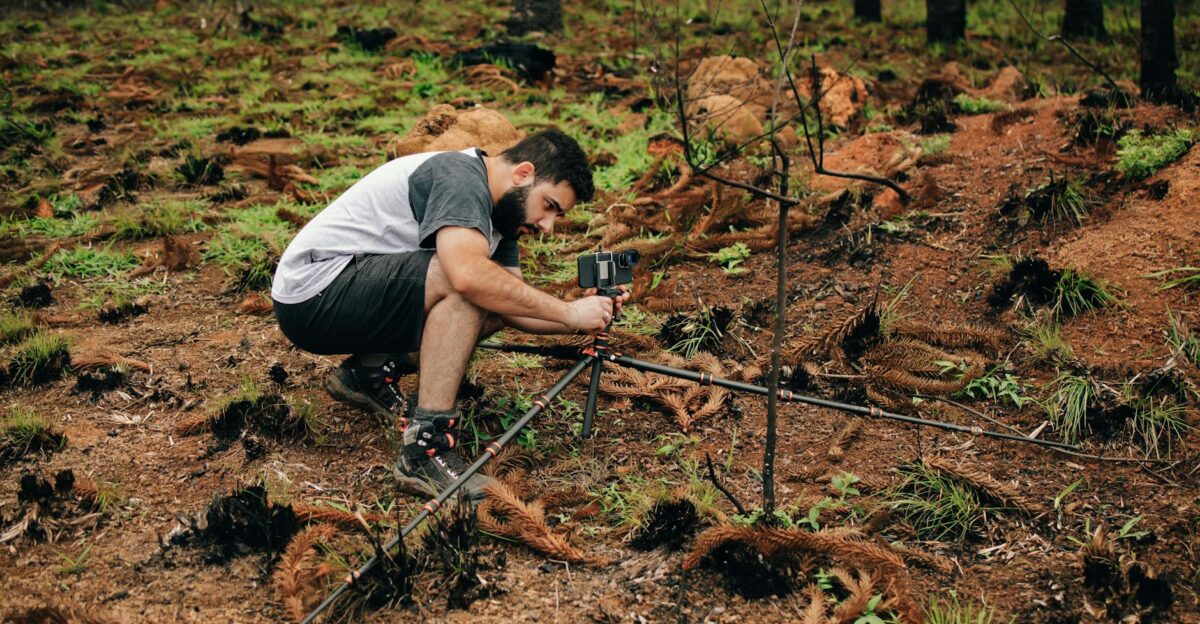 A man setting up equipment in a forest for environmental research