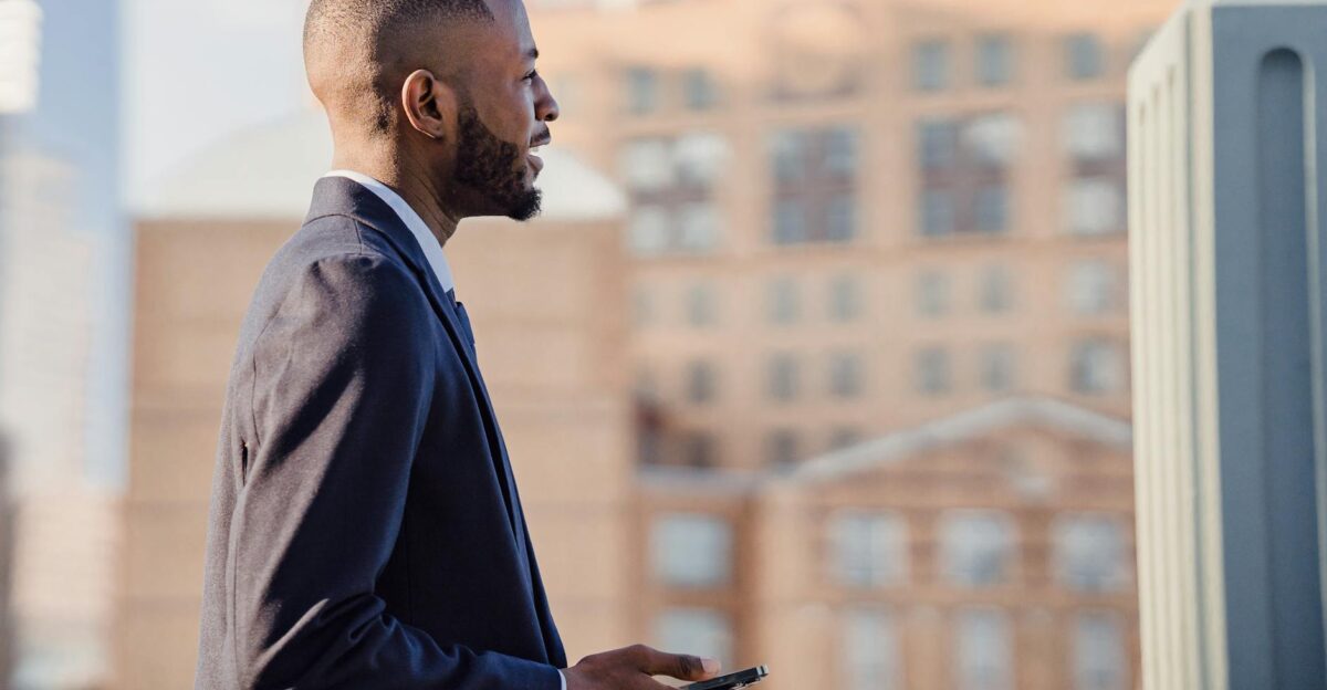 African American businessman with smartphone in outdoor urban setting Professional attire and modern technology