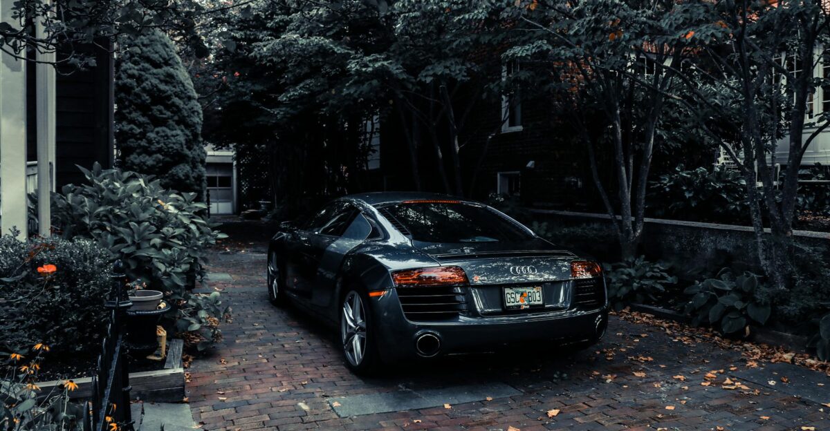 A sleek Audi R8 parked in a leafy residential driveway in Cape May NJ showcasing elegance and luxury