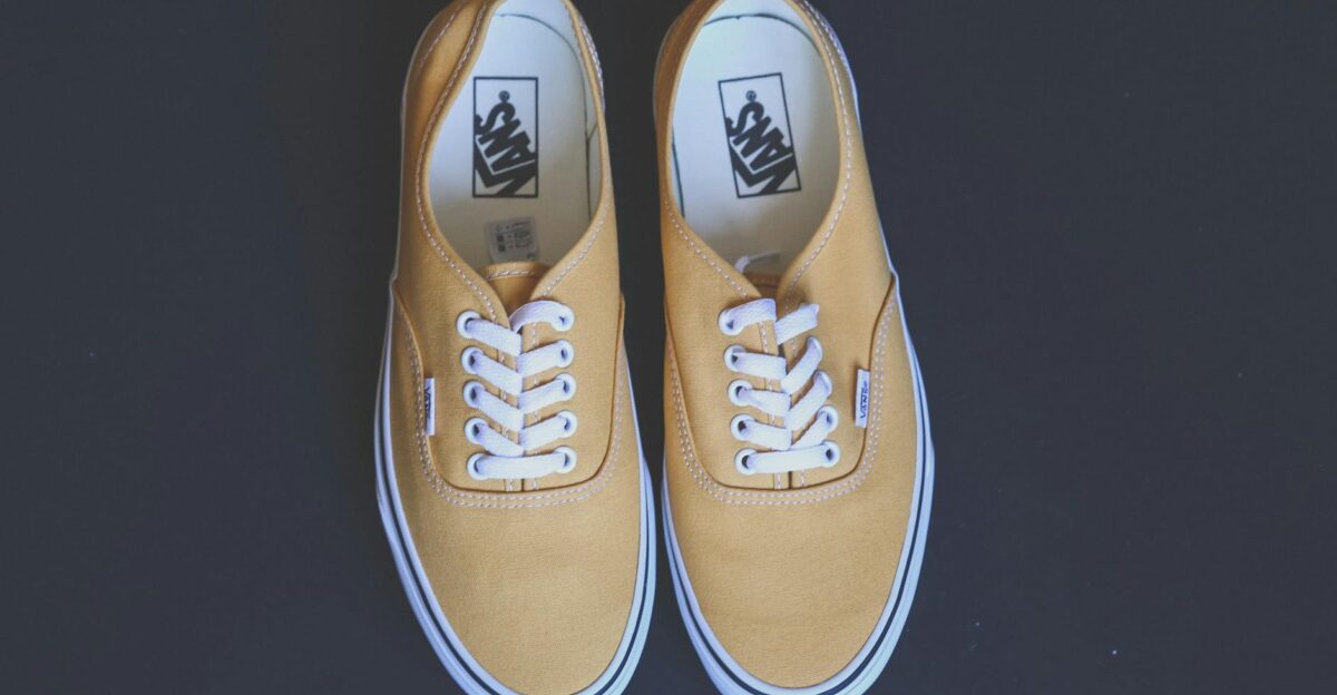 Pair of stylish yellow sneakers on a black background showcasing fashion and footwear design