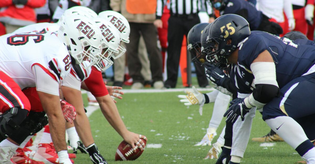 Rival football teams face off at the start of an action-packed game on the field