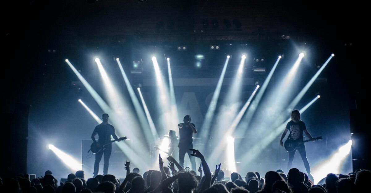 Energetic live concert with musicians performing on stage engaging the crowd with vibrant lighting effects