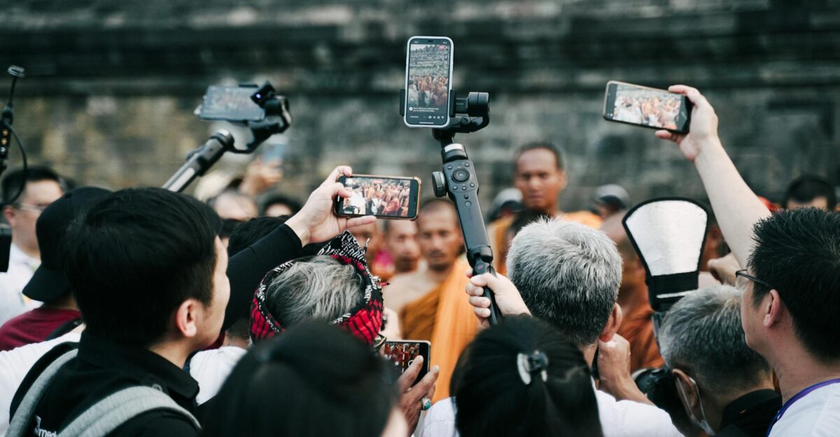 A crowd uses smartphones to capture a Buddhist ceremony at a historic site