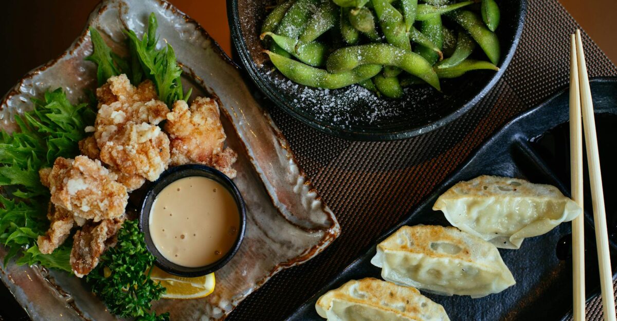 Delicious Asian dishes including dumplings fried chicken and edamame perfect for a savory dining experience