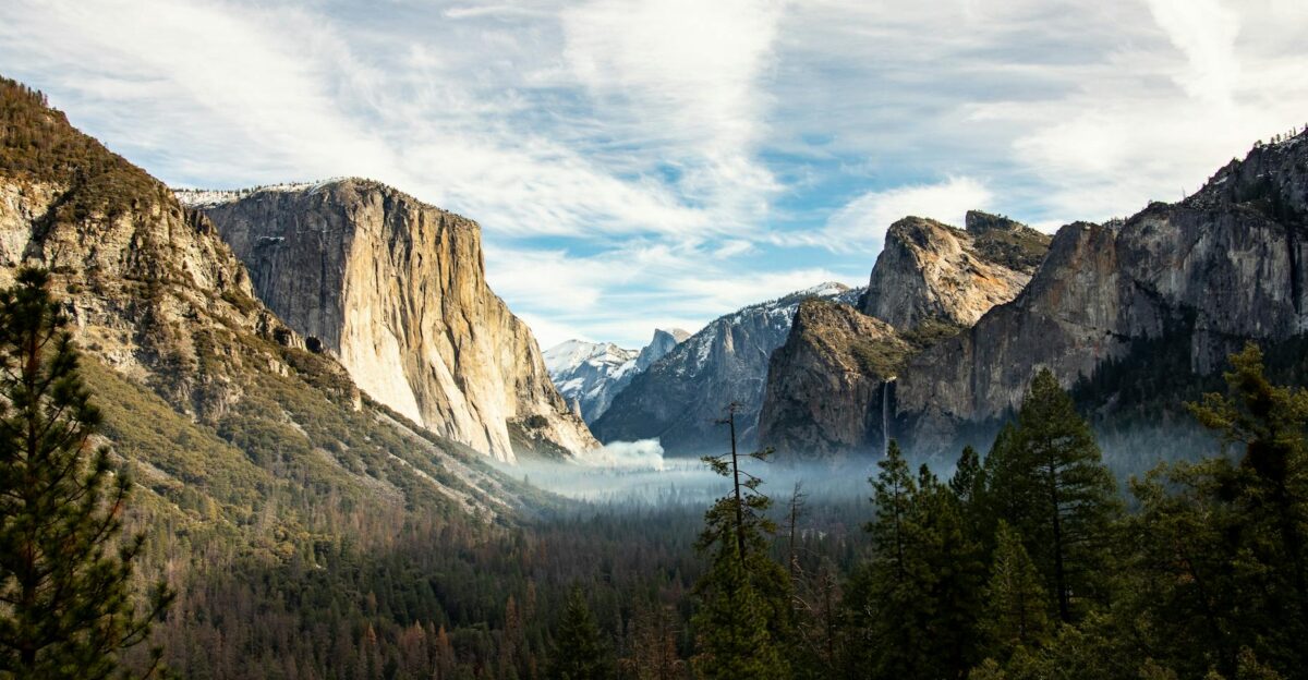Majestic view of Yosemite Valley featuring El Capitan and surrounding mountains under a blue sky