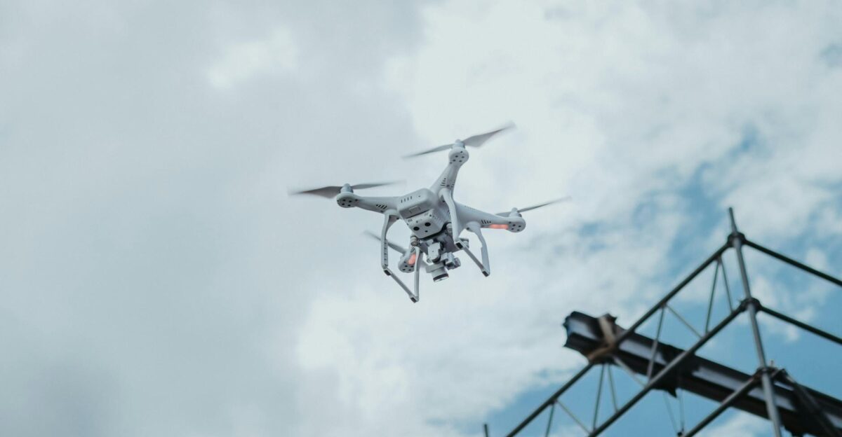 A drone hovering in the sky amidst clouds showcasing technology in action