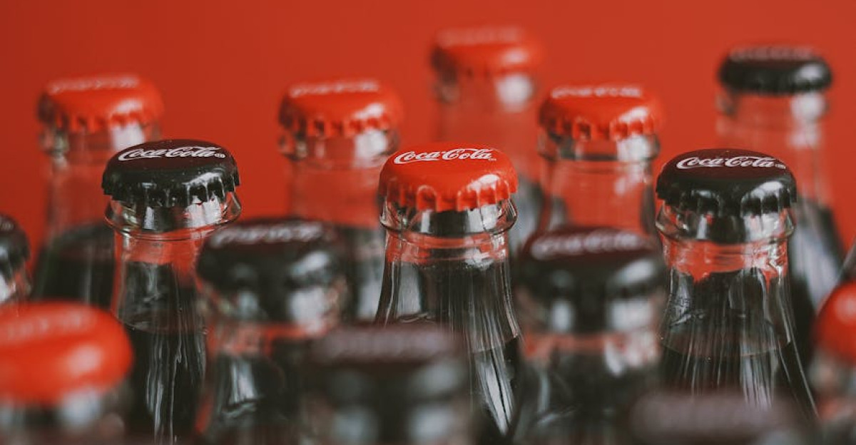 A close-up of Coca-Cola bottle tops with a focus on red caps against a red background