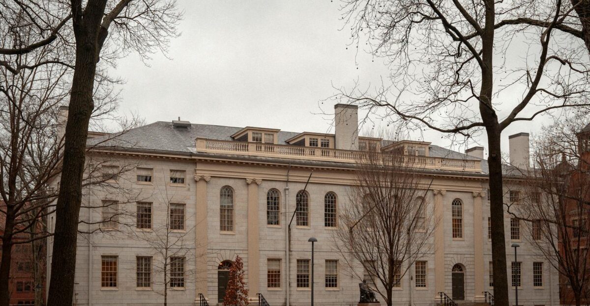 A historic university building surrounded by barren trees on an overcast autumn day