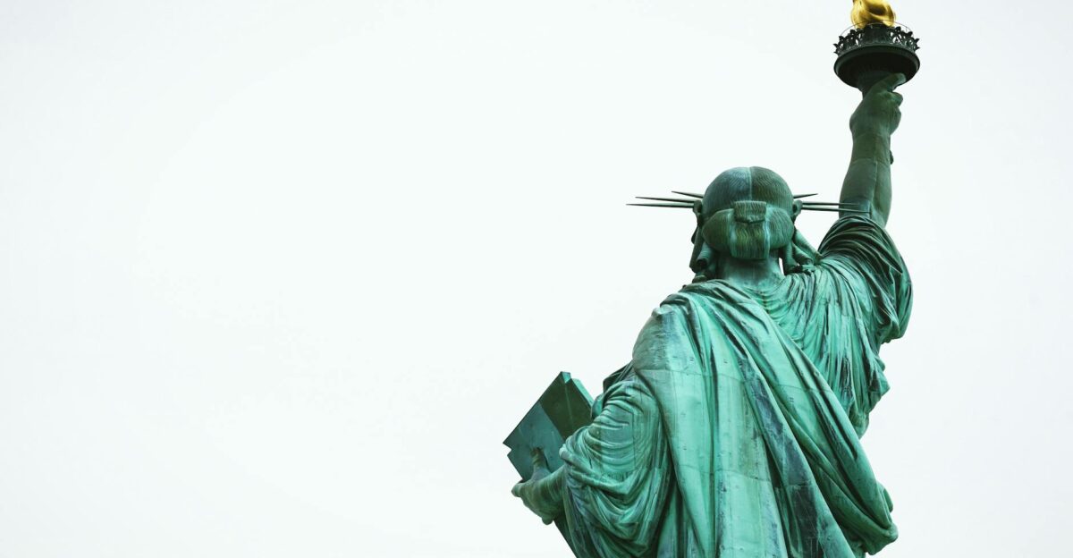 The Statue of Liberty stands tall against a clear sky symbolizing freedom in New York City