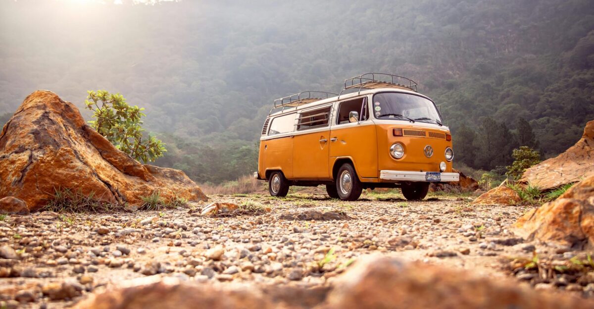 Classic VW van parked on rocky terrain with mountains in Alegr a El Salvador