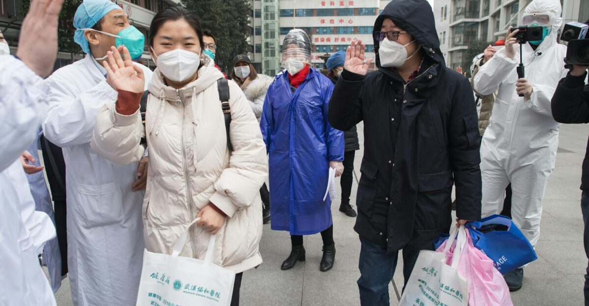 Healthcare workers and people in masks interacting outdoors during COVID-19 pandemic