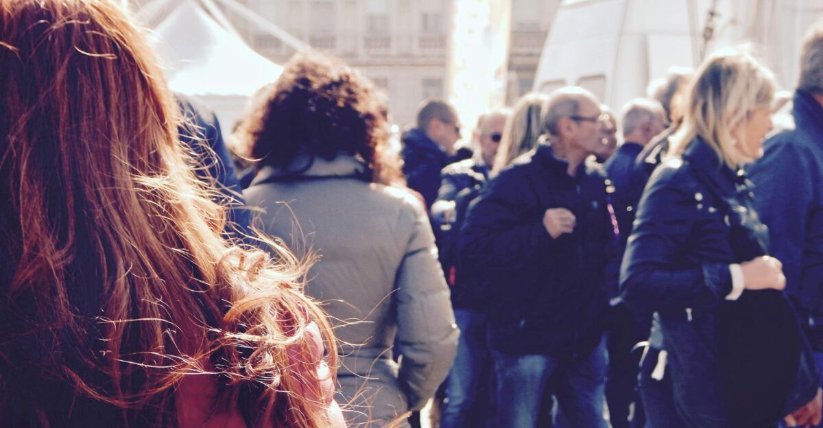 A lively group of people gathers in an outdoor setting during daytime
