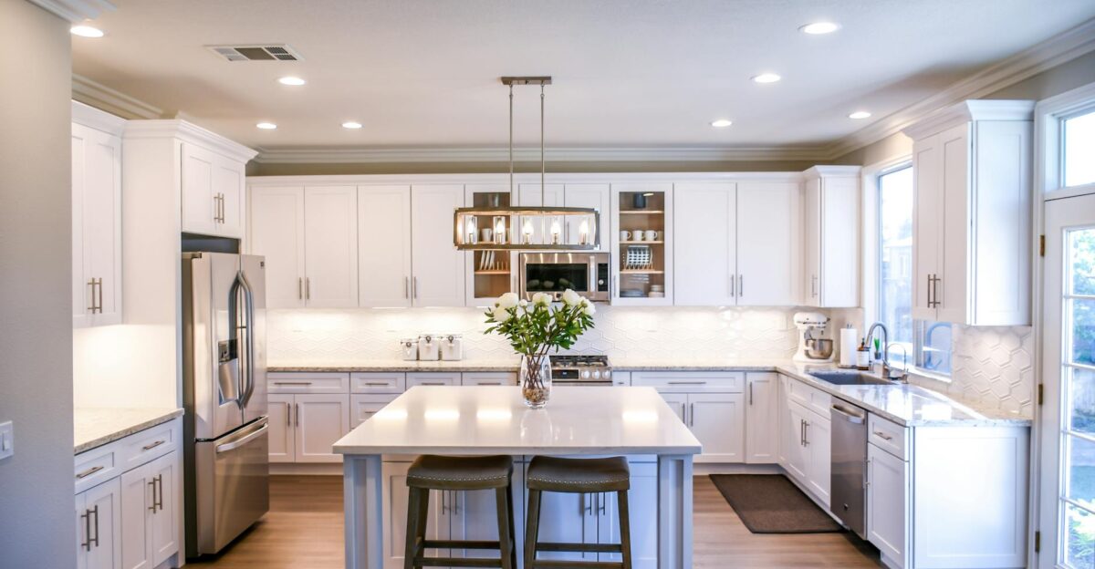 Spacious and elegant kitchen featuring white cabinetry island and stainless steel appliances