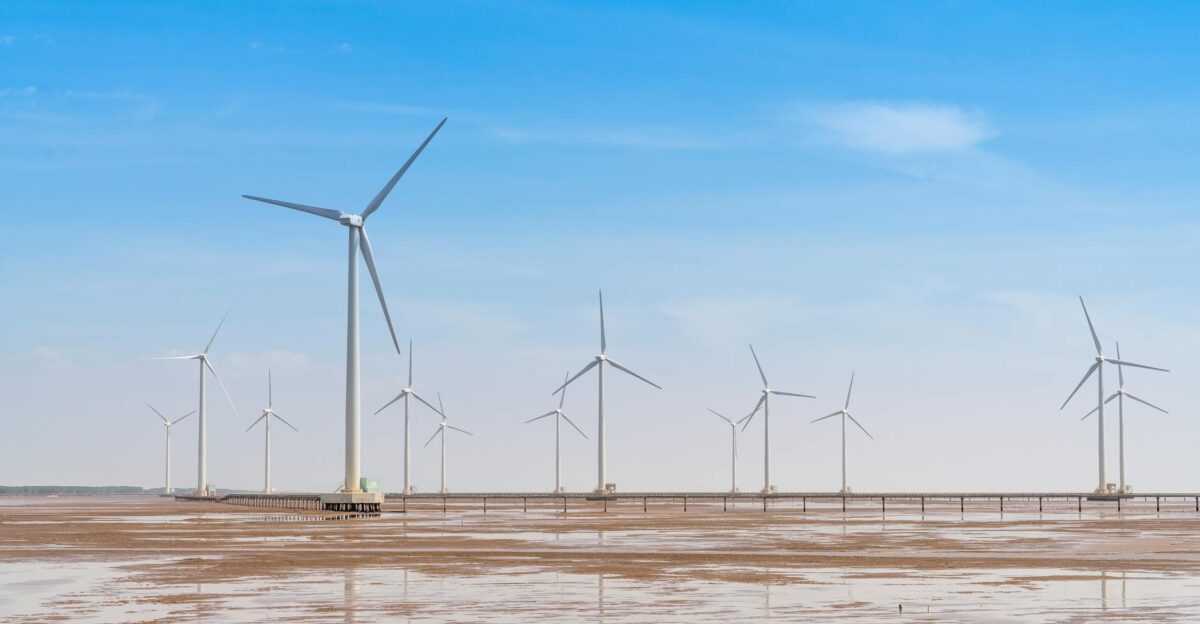Expansive wind farm with turbines under a bright blue sky showcasing renewable energy