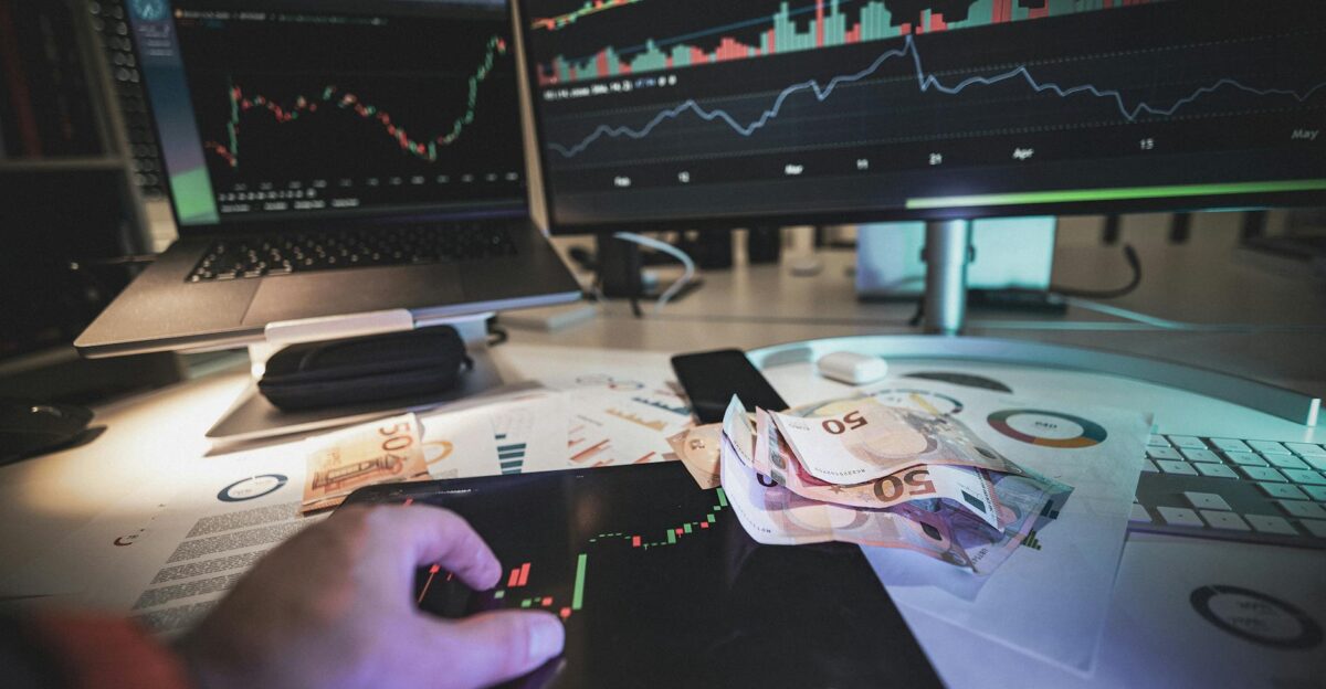 A modern trading desk with screens showing market charts and euro notes capturing a trading atmosphere