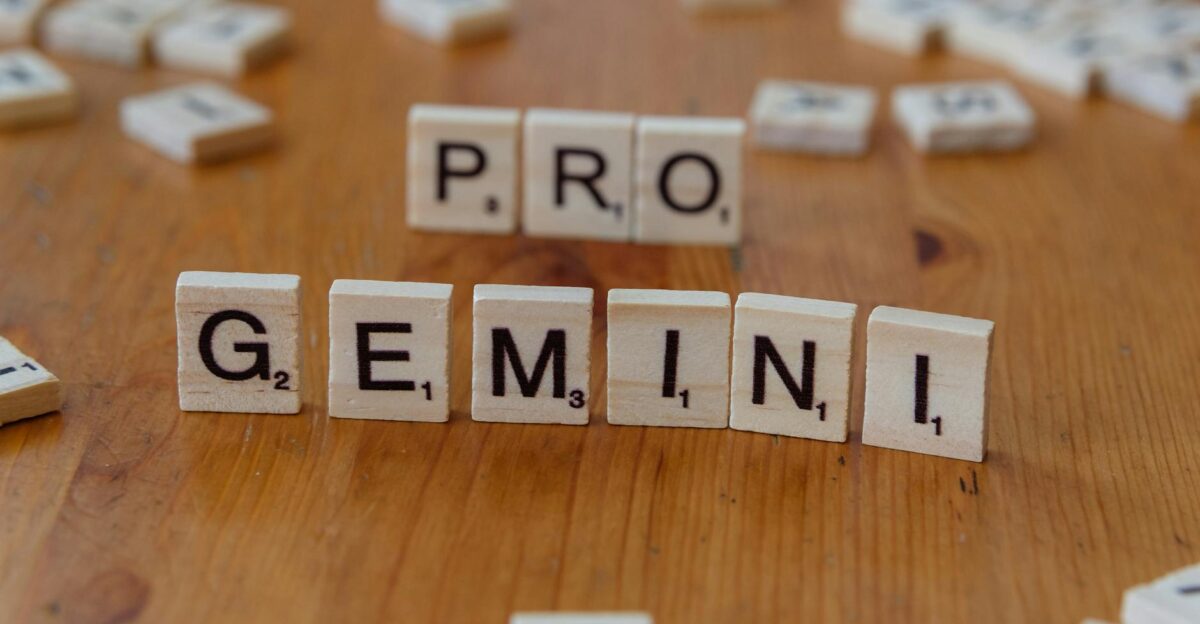 Scrabble tiles arranged to spell PRO GEMINI on a wooden table ideal for creativity themes