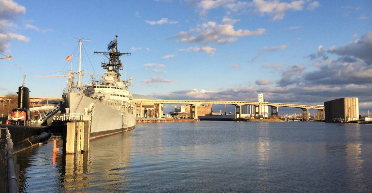 USS Little Rock docked at Buffalo waterfront with city bridge skyline and serene waters