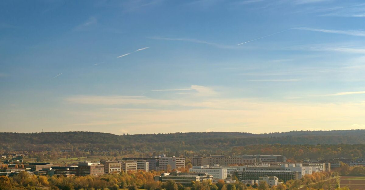 A panoramic view of Stuttgart s industrial district with buildings and greenery under a clear blue sky