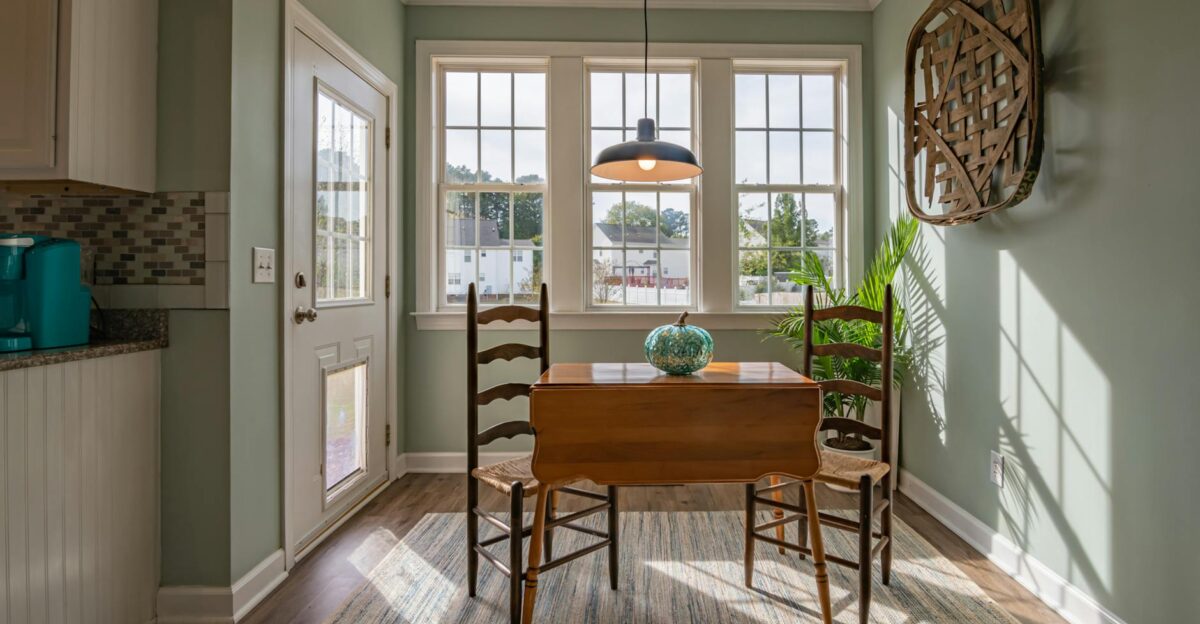 Bright dining area with wooden furniture and large windows showcasing natural light