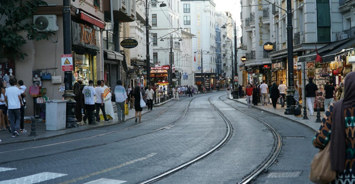 Vibrant street scene showing people shopping on a busy Istanbul street with tram tracks