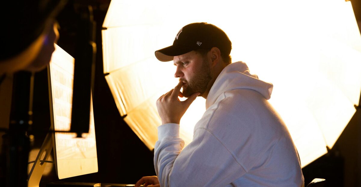 Contemplative man working on computer with professional studio lighting setup