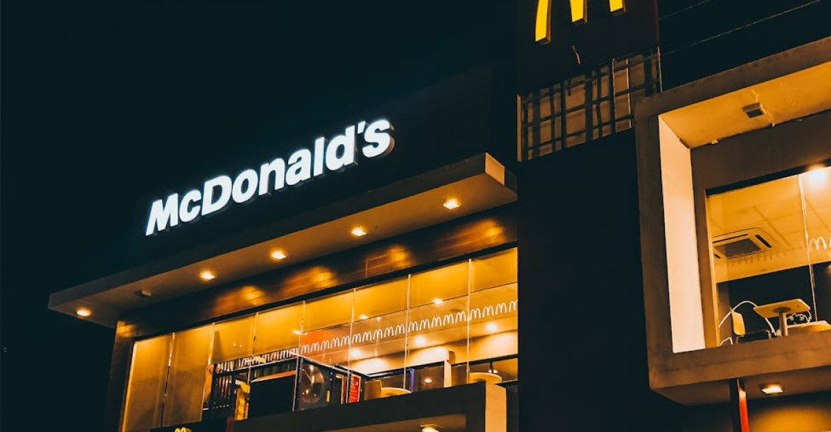 Exterior view of McDonald s in Cauayan City Philippines illuminated at night with cars and people