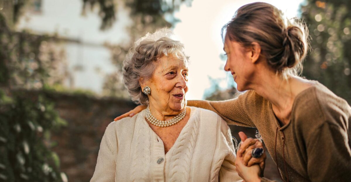 Elderly woman and adult daughter share a joyful affectionate moment in a sunny garden
