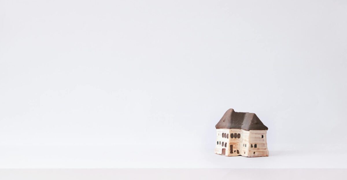 Simple handmade clay house on a plain white background perfect for creative design projects