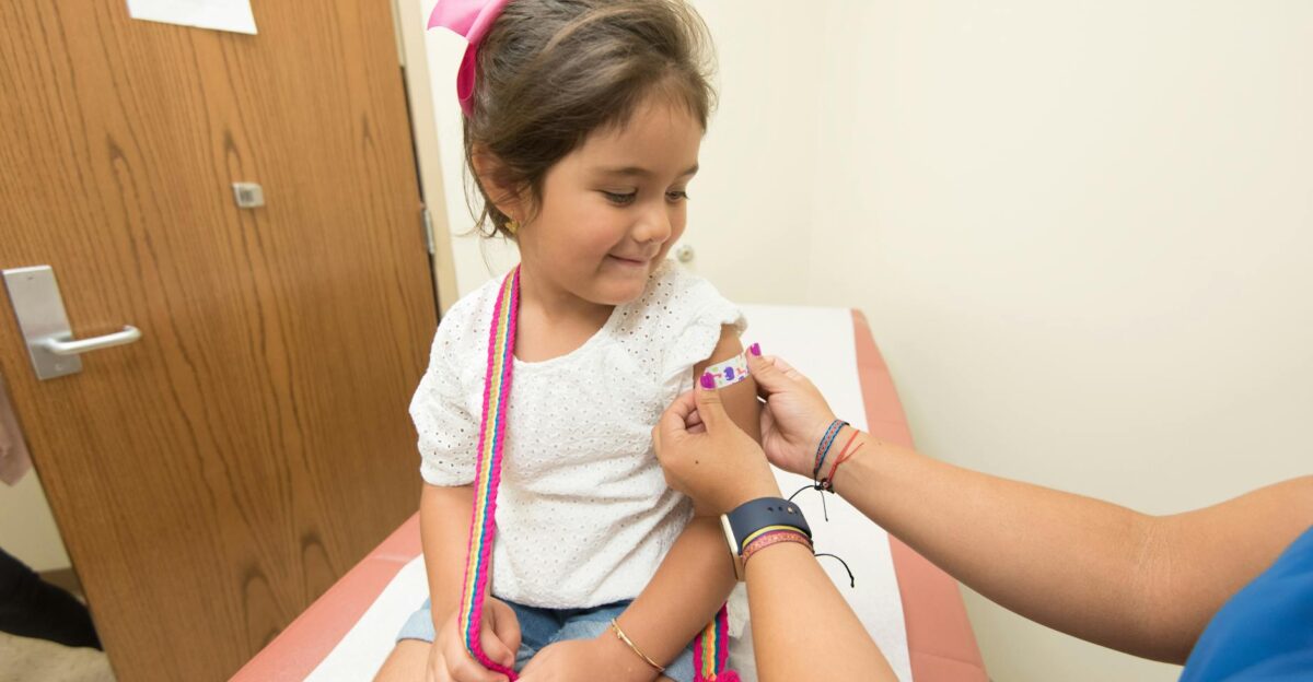 A cheerful young girl receives a band-aid after a vaccination at a clinic