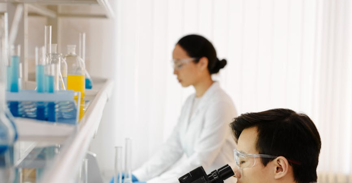 Two scientists working with microscopes and beakers in a modern laboratory setting