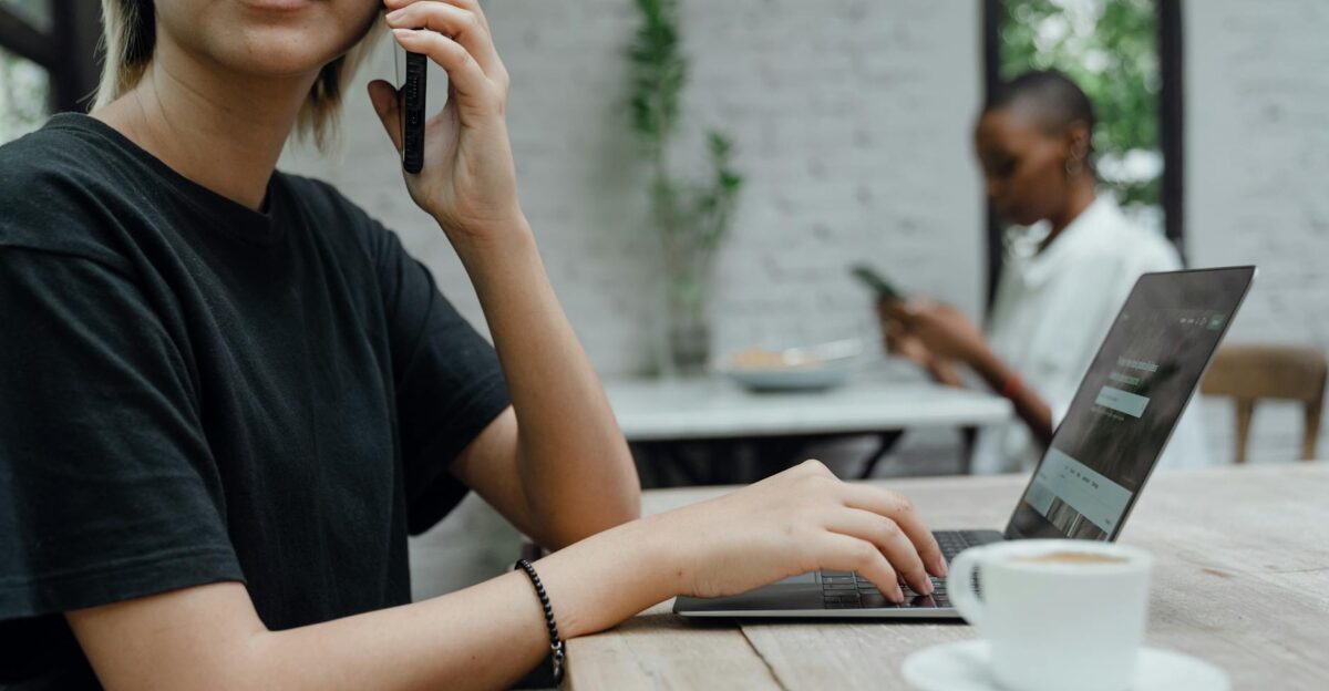 People working remotely in a modern caf using laptops and phones for business tasks