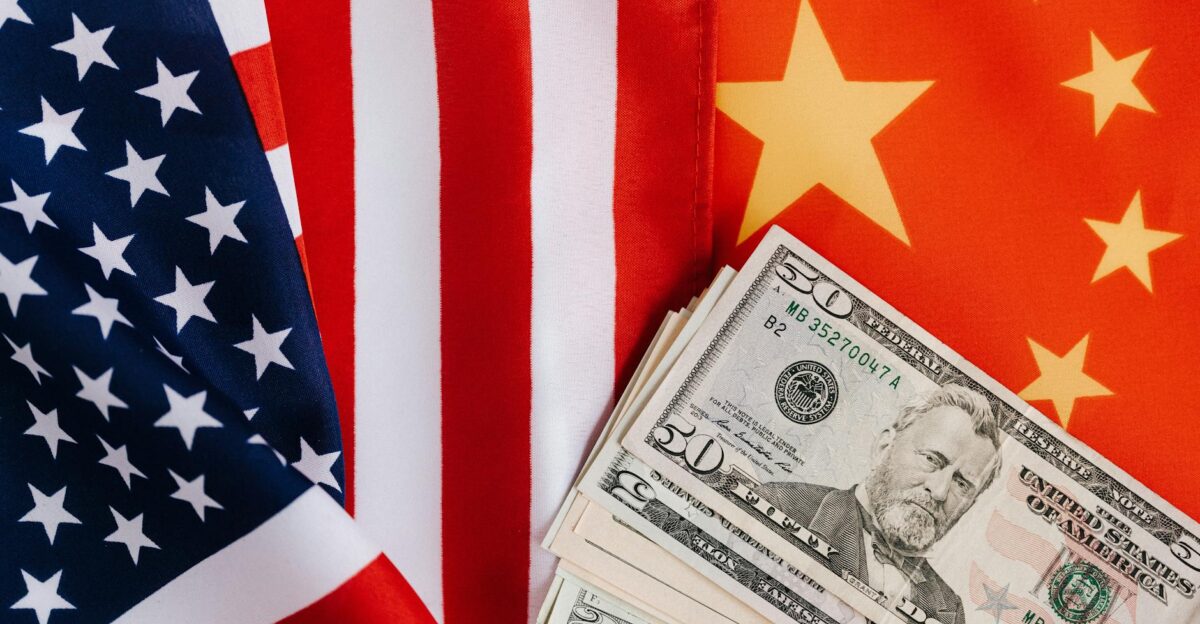Close-up of US and China flags with US dollar bills representing international trade and finance