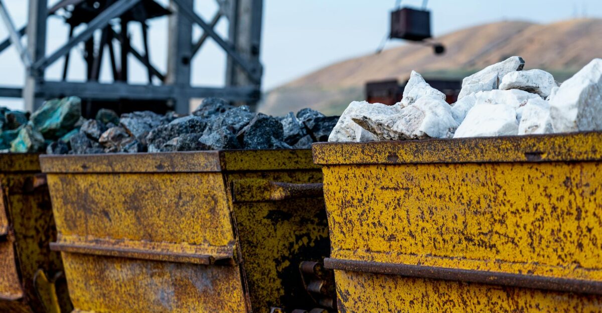 Close-up of rusty mining carts filled with various minerals in an industrial setting