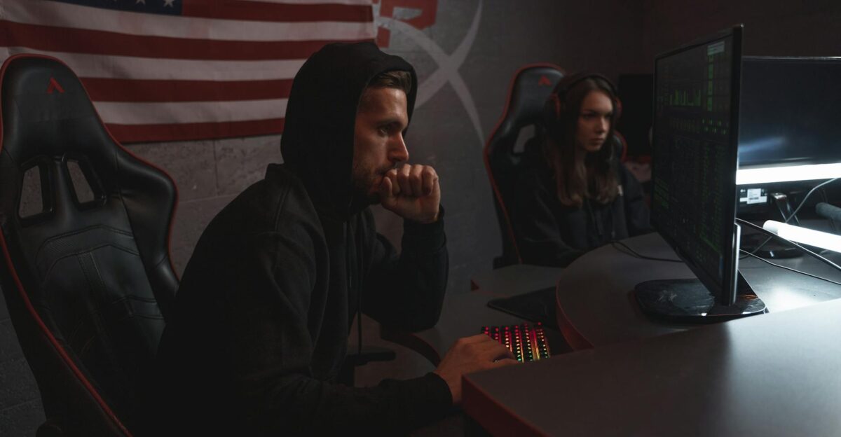 Two individuals analyze data in a dimly lit cybersecurity setting highlighting digital defense themes