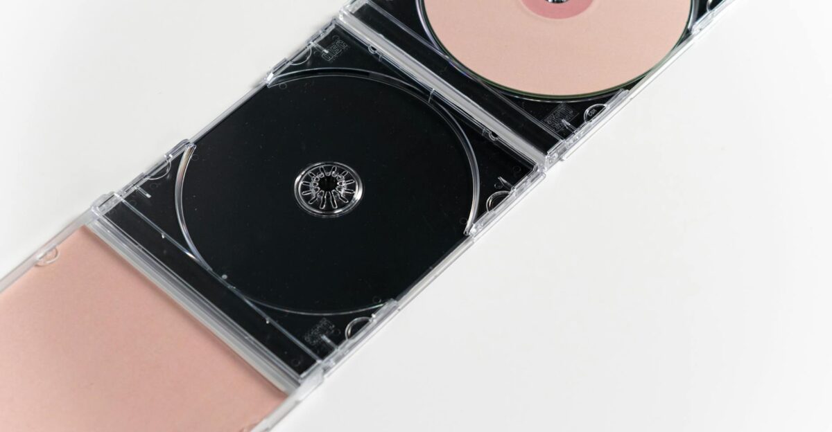 Artistic flat lay of open CD cases on a white surface showcasing compact discs