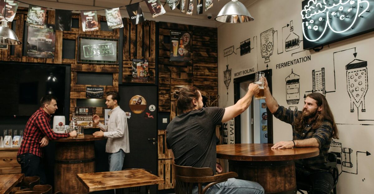 Friends enjoying beer indoors at a stylish bar clinking glasses in a lively atmosphere