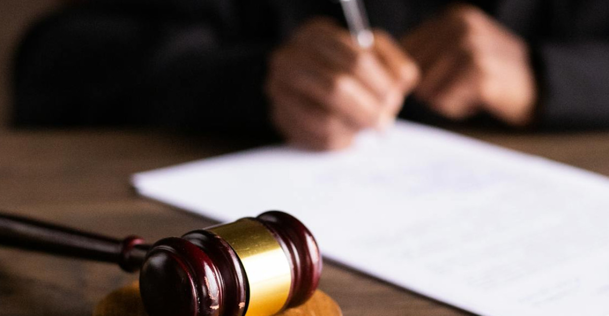 Judge signing documents at desk with focus on gavel representing law and justice