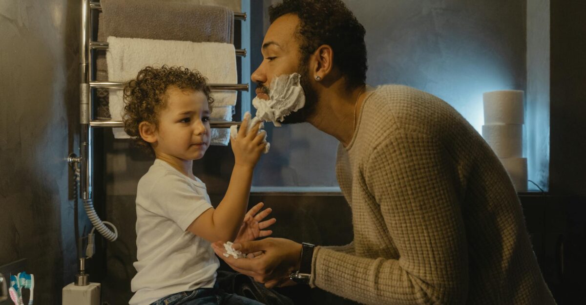 A father and son enjoy playful shaving time together emphasizing family bonding and care
