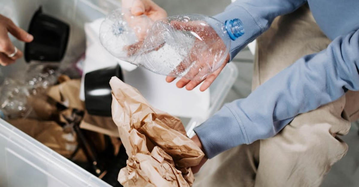 Volunteers in blue shirts sorting recyclable materials like paper and plastic