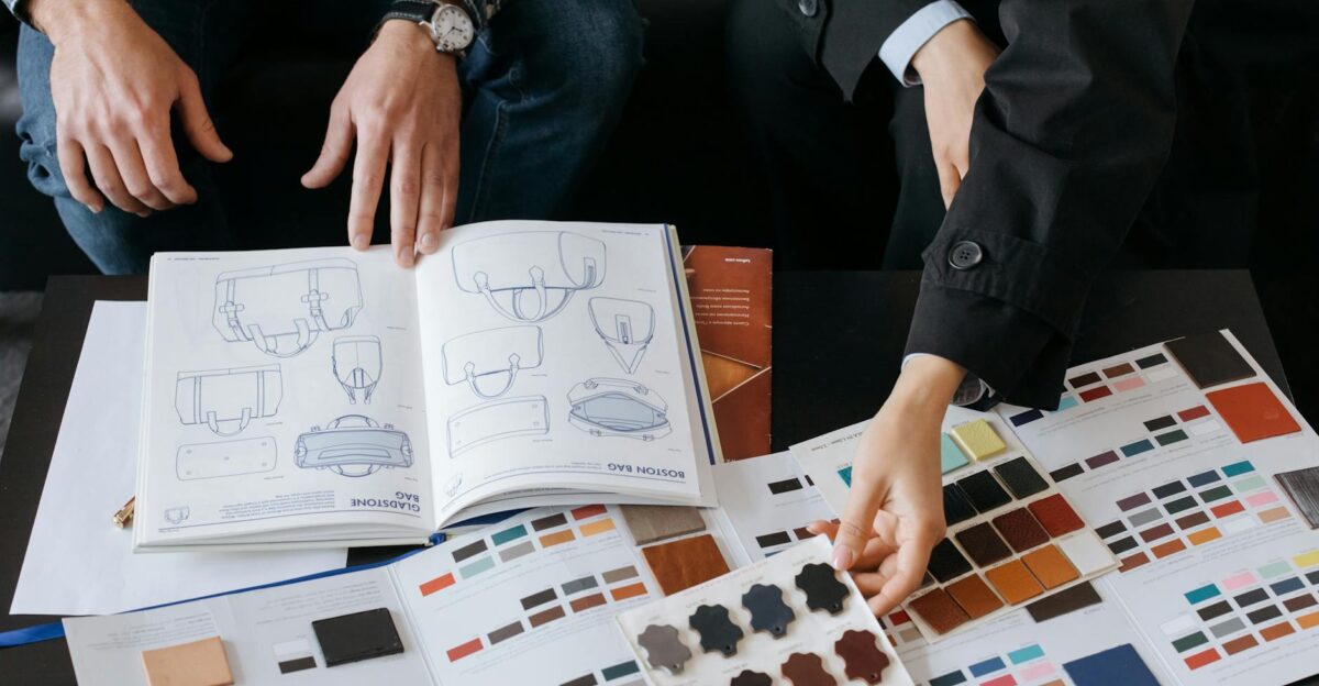 Two professionals choosing color swatches and bag designs for a fashion project