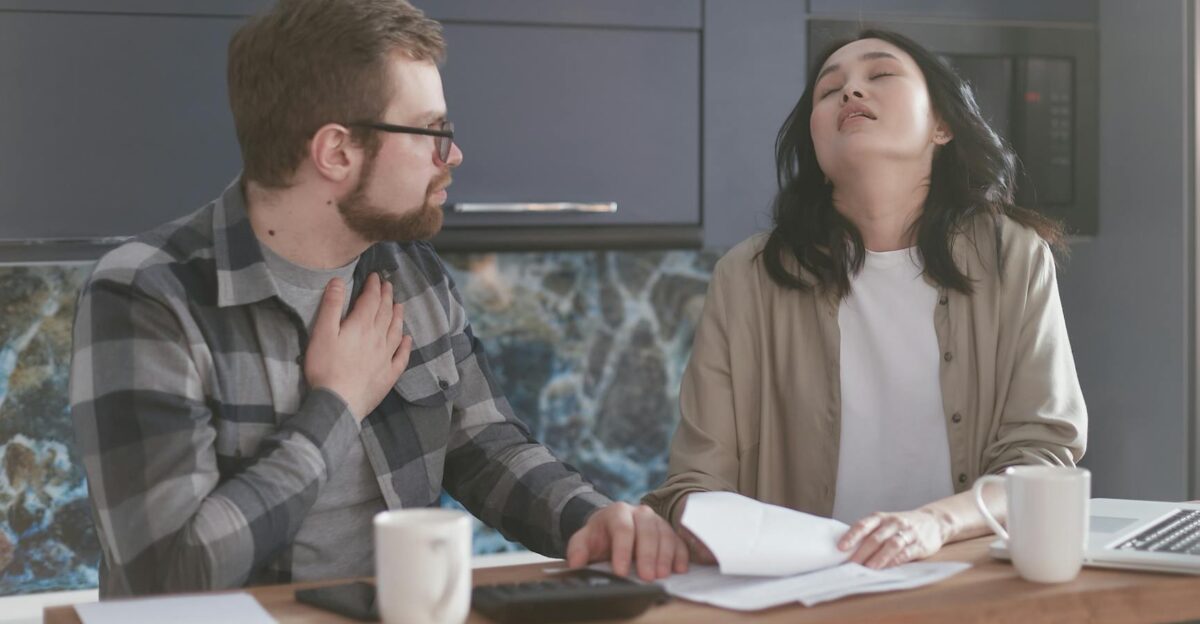 A couple experiencing stress while discussing finances in a modern kitchen setting