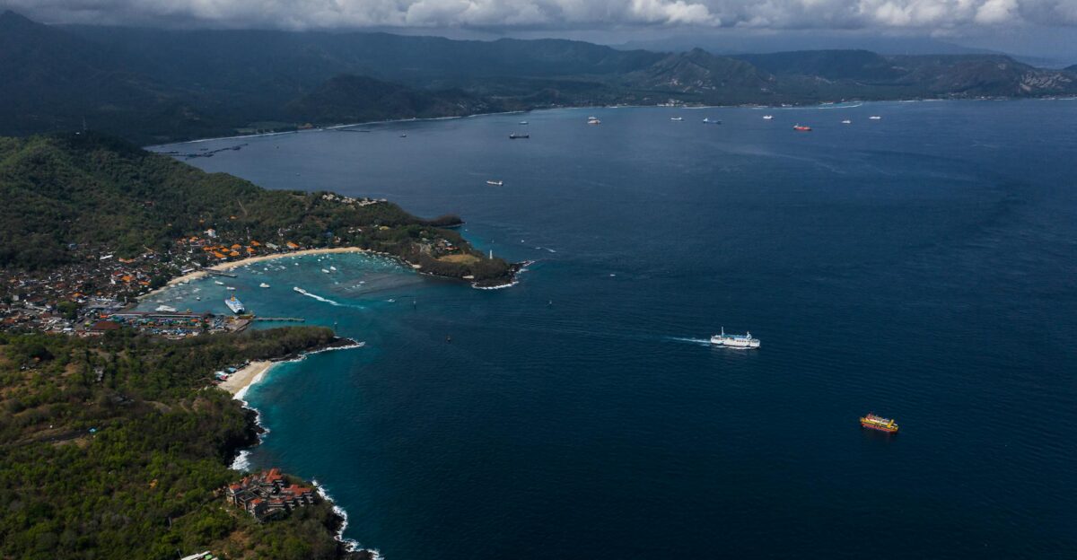 Aerial shot of the Bali coastline with lush greenery and tranquil ocean waters