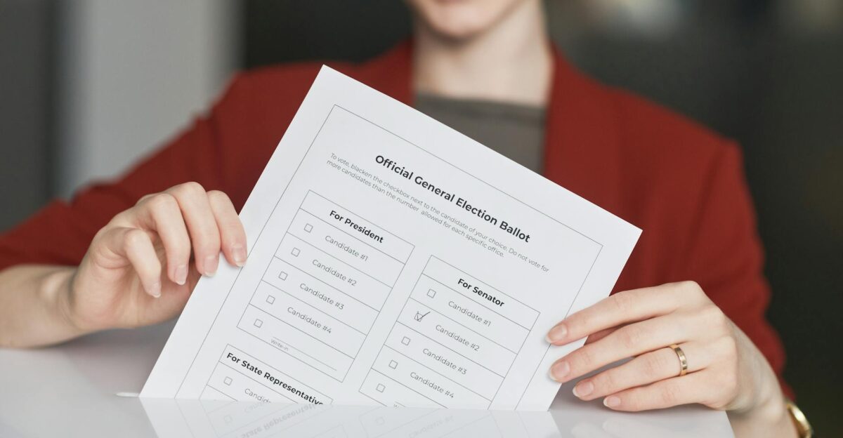 Smiling woman holds an election ballot paper during voting day