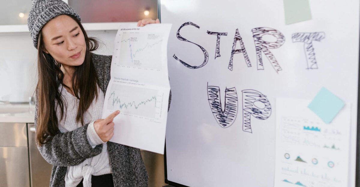 Asian woman presenting business growth charts during a startup pitch indoors