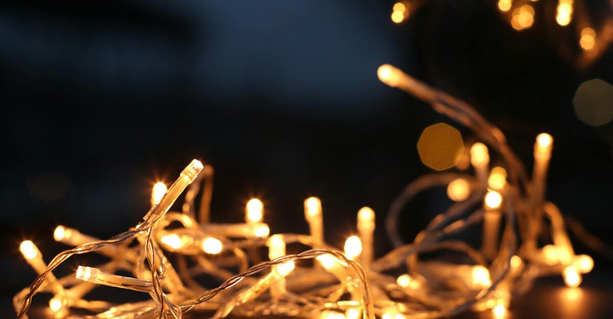 Close-up of warm LED string lights glowing against a dark background