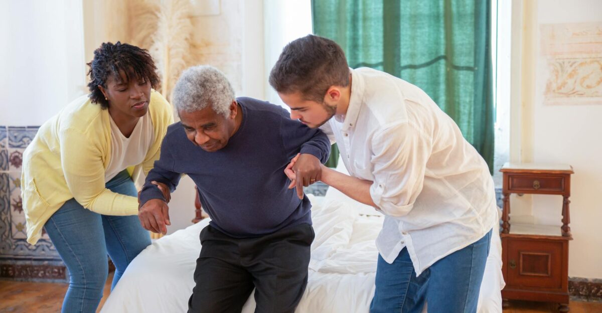 An elderly man receiving assistance from caregivers in a cozy home environment