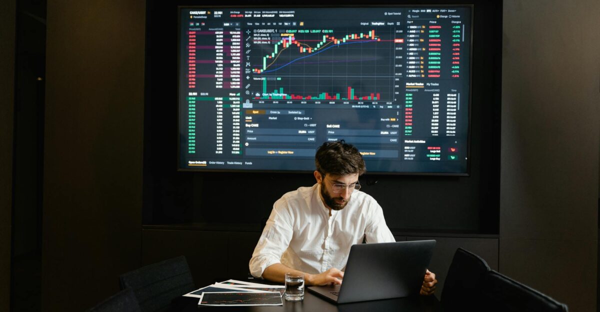 Businessman using laptop in office analyzing stock market charts Professional finance and investment concept