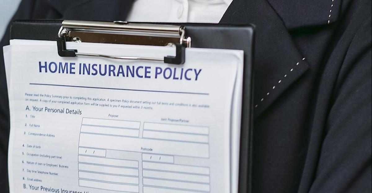 Close-up of a person holding a home insurance policy on a clipboard captured indoors